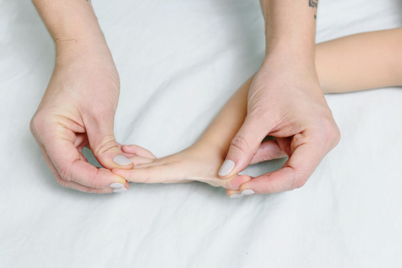 Close-up of hands giving gentle massage to childs hand, promoting relaxation.